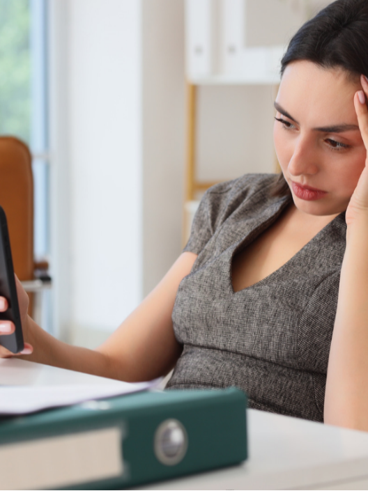 Woman looking at her phone with a worried expression